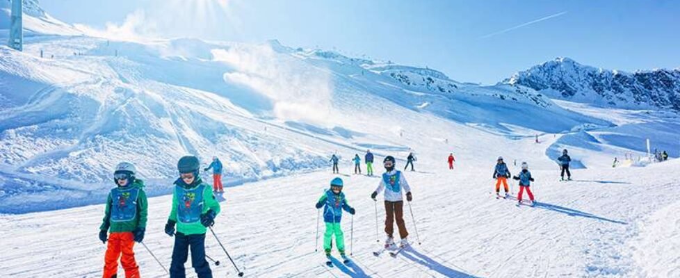 Group of Children Skiers with instructor skiing in Hintertux Glacier