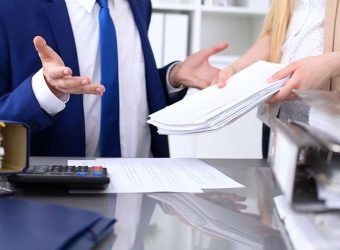 Bookkeeper or financial inspector and secretary making report, calculating or checking balance. Internal Revenue Service inspector checking financial document. Audit concept.