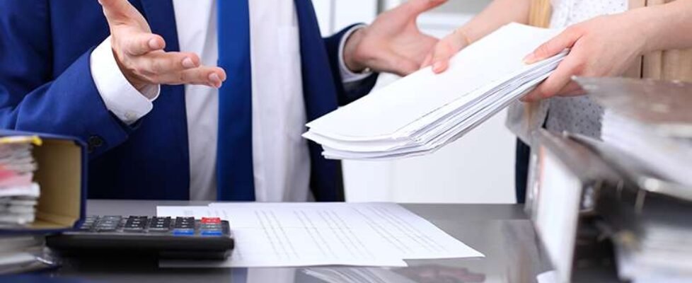 Bookkeeper or financial inspector and secretary making report, calculating or checking balance. Internal Revenue Service inspector checking financial document. Audit concept.