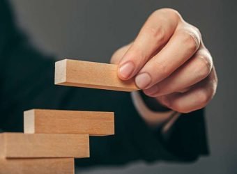 Man and wooden cubes on table. Management concept