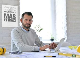 Young Architect with Laptop Looking at Camera in Office