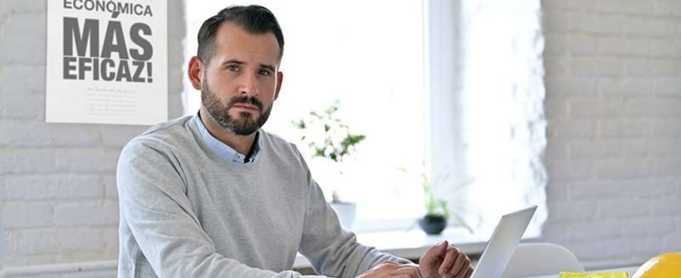 Young Architect with Laptop Looking at Camera in Office