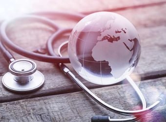 glasd global and stethoscope on wood table, healthcare concept,