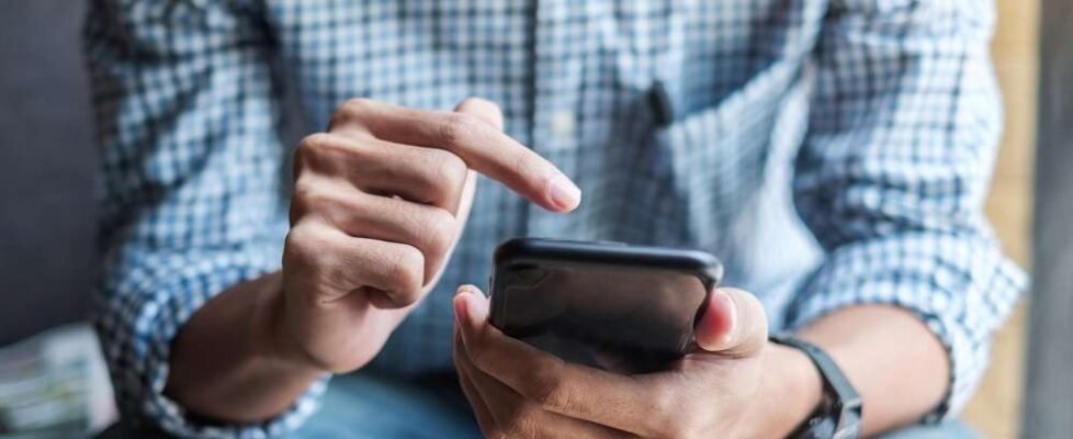 Young casual Businessman holding and using smartphone for sms me