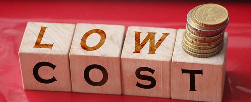 Low cost words on Wooden blocks, down arrow and business team. Unsuccessful business and bankruptcy. Profit decline. Loss of investment. Economic crisis. The fall of the financial market. Recession