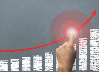 composite of hand pointing at rising graph