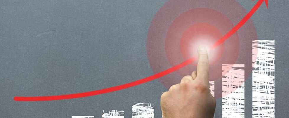 composite of hand pointing at rising graph