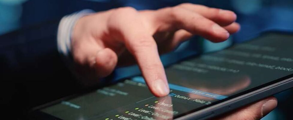 Male system administrator inspecting big data on tablet