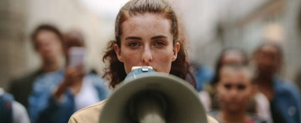 Female activist protesting with megaphone during a strike