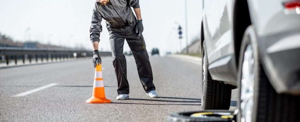 Worker putting emergency cones near the car