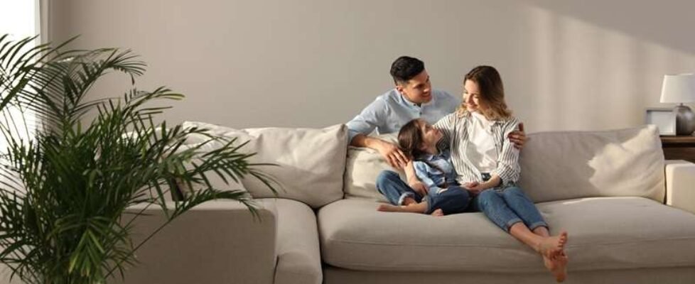 Family,With,Little,Daughter,Resting,On,Sofa,In,Living,Room