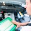 Mechanic with diagnostic tool in car workshop