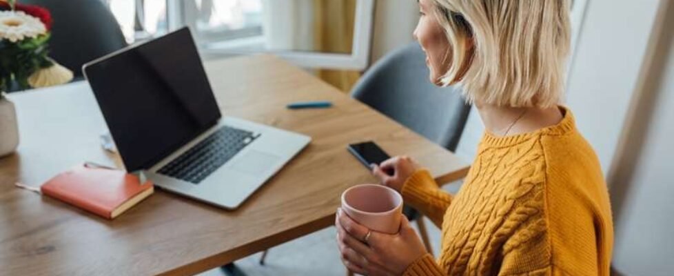 Young woman drinking morning coffee and starting her online work