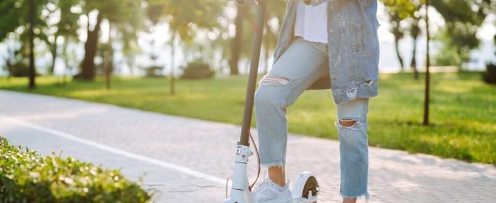 Women's legs on electric scooter outdoors. Electric vehicles. Ecological transport. Active lifestyle