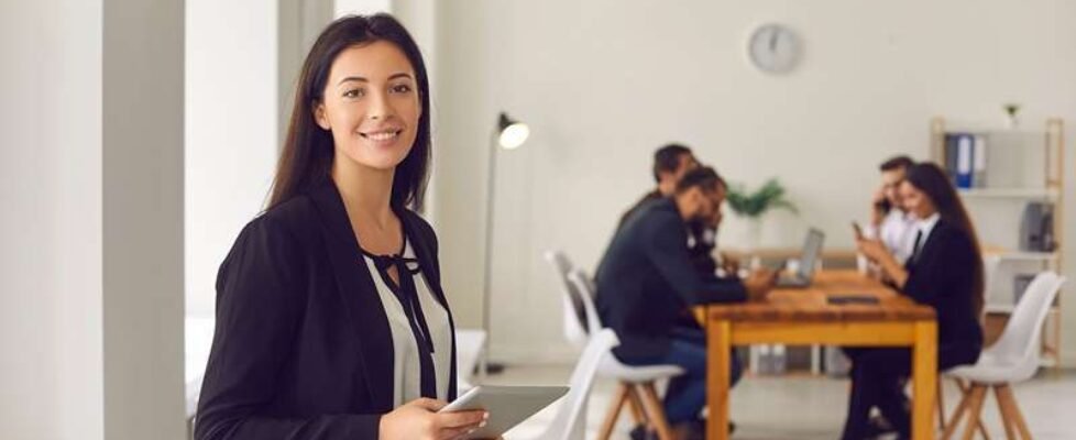 Portrait,Of,Happy,Female,Business,Leader,Holding,Tablet,Standing,In