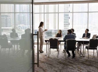 Wide,Shot,Of,Multiethnic,Business,Team,Talking,At,Meeting,Table