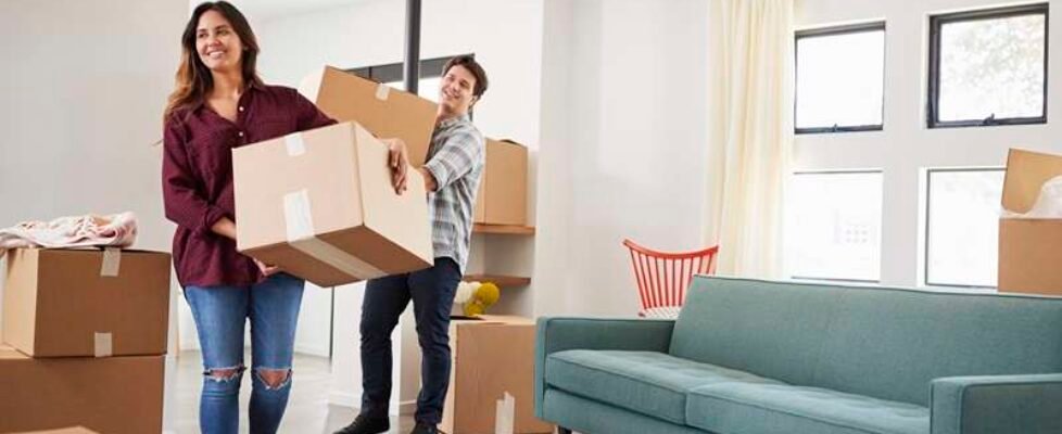 Excited Couple Carrying Boxes Into New Home On Moving Day