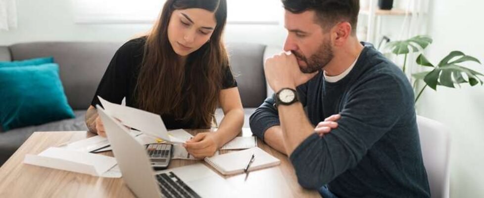 Stressed married couple checking their bills and debts
