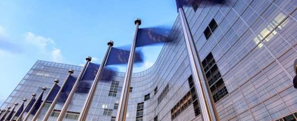 Waving flags of European Union in front of European Comission building