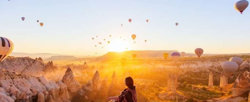 Young,Woman,Admire,Scenery,Of,Hot,Air,Balloons,Flying,Over