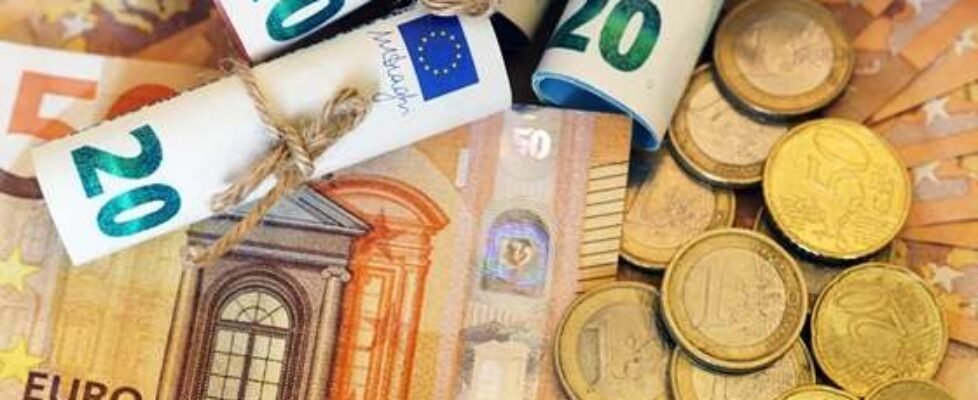 High angle shot of some rolled banknotes and coins on more banknotes