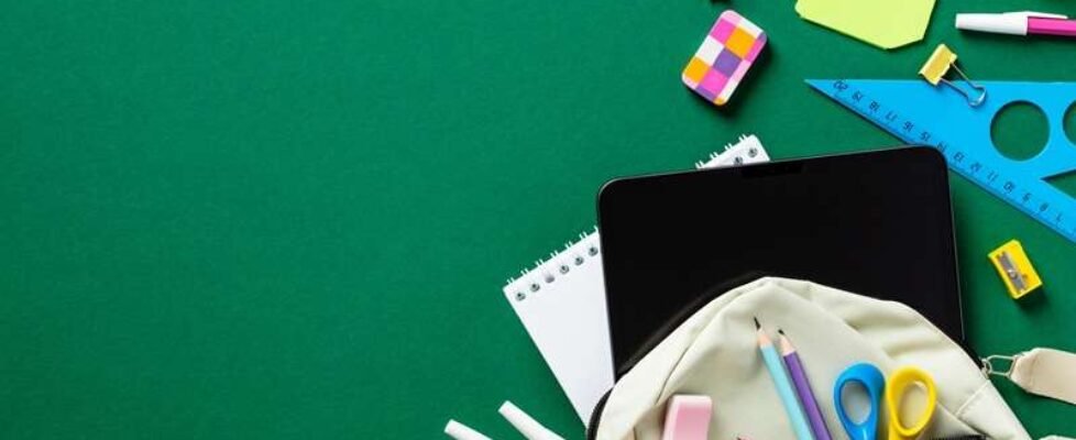 School stationery in open backpack on green background. Back to school concept. School supplies. Flat lay, top view.